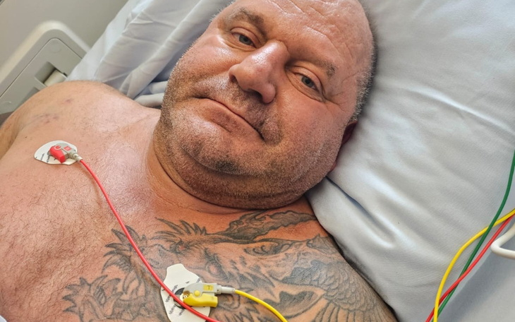 Mężczyzna w szpitalu z monitorami na klatce piersiowej.