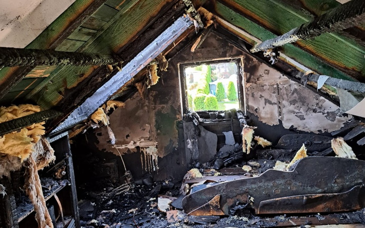 Wnętrze spalonego domu, zniszczone meble i ściany.