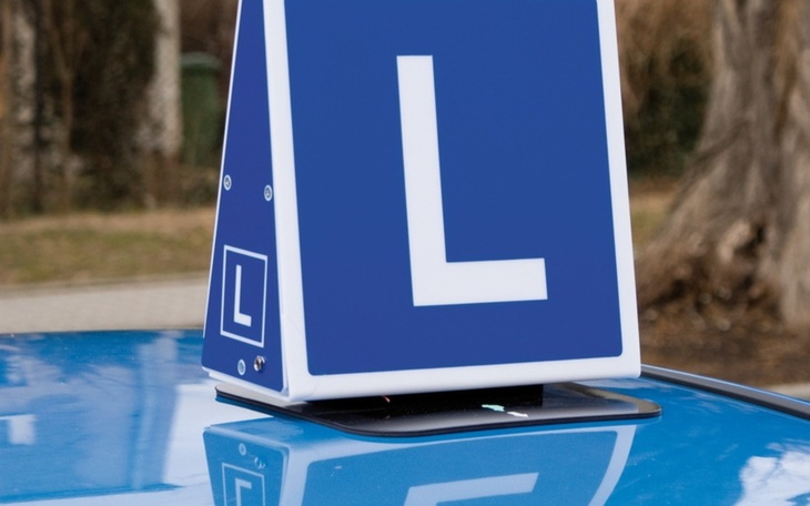 Znak L na dachu samochodu, symbol nauki jazdy.