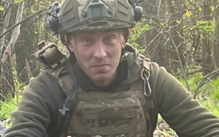 Żołnierz w mundurze, siedzi w lesie.