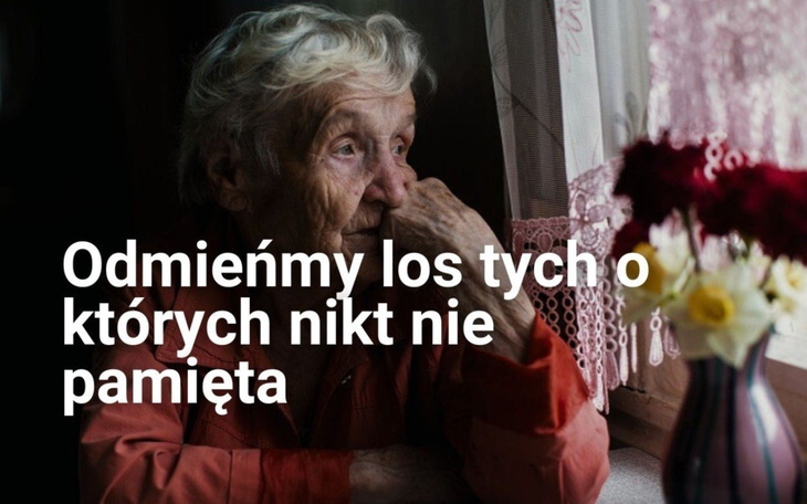 Starsza kobieta patrząca przez okno z kwiatami.