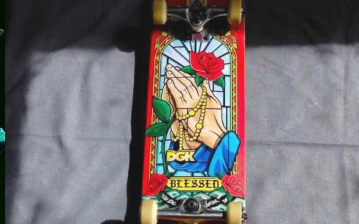 Deska skateboardowa z motywem religijnym i różami.