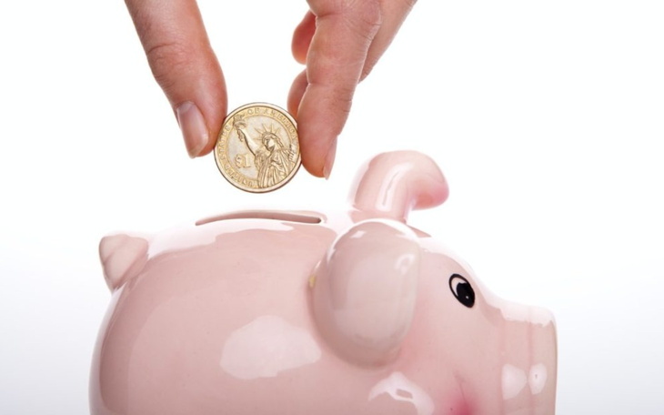 Skarbonka w kształcie świnki z monetą wkładaną do środka.