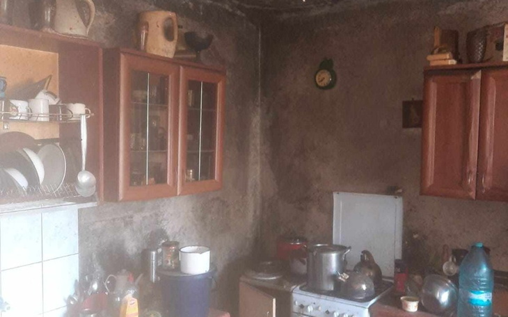 Zaniedbana kuchnia z brudnymi naczyniami i starym sprzętem.