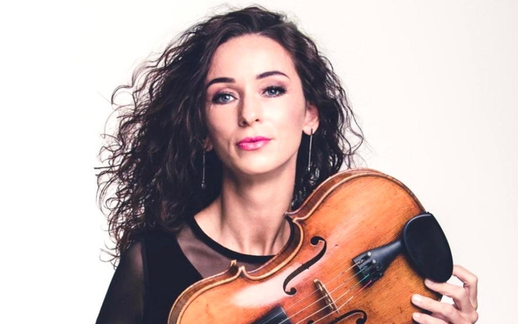 Kobieta z skrzypcami, pozująca do zdjęcia.