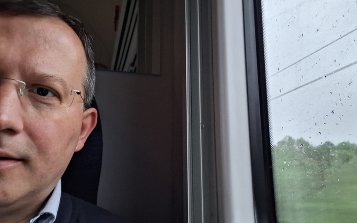 Mężczyzna w pociągu, selfie z widokiem za oknem.