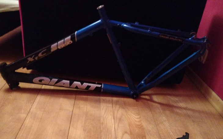 Rama rowerowa leżąca na podłodze, gotowa do naprawy.