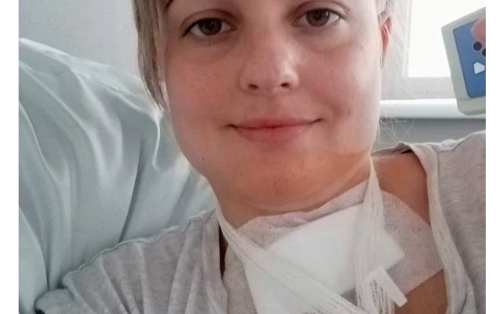 Kobieta w szpitalu, uśmiechająca się do kamery.