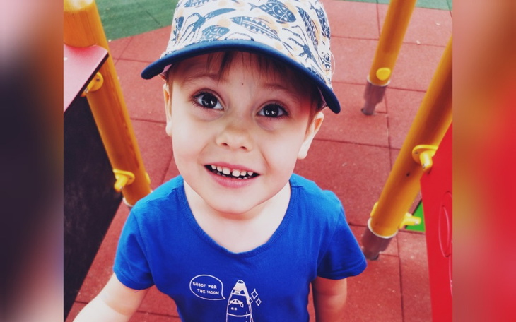 Chłopiec bawiący się na placu zabaw, uśmiechnięty.