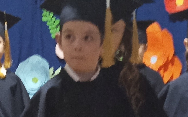 Chłopiec w czapce absolwenta, na ceremonii ukończenia szkoły.