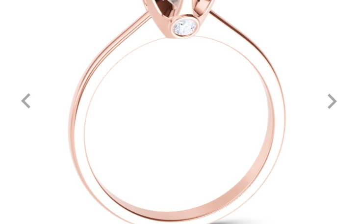 Złoty pierścionek z diamentem na białym tle.