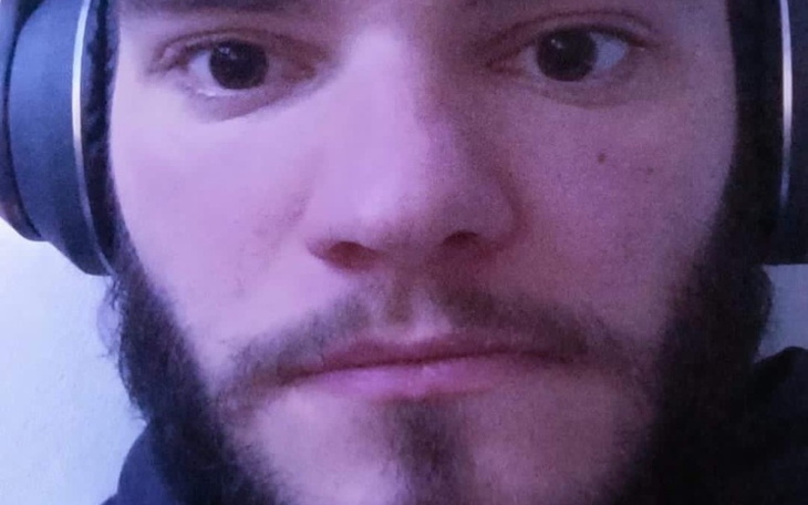 Mężczyzna z słuchawkami, patrzący w kamerę.