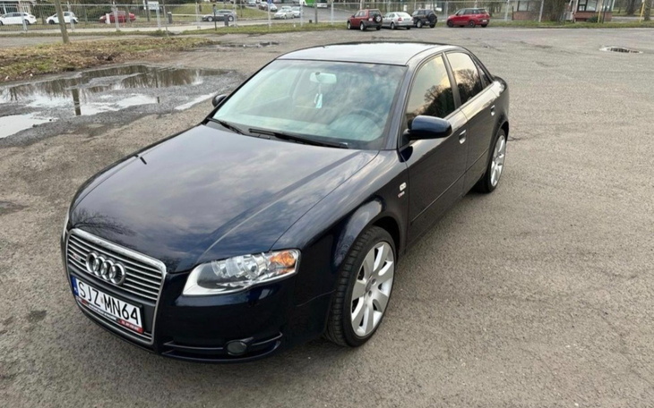 Czarny samochód osobowy zaparkowany na parkingu.