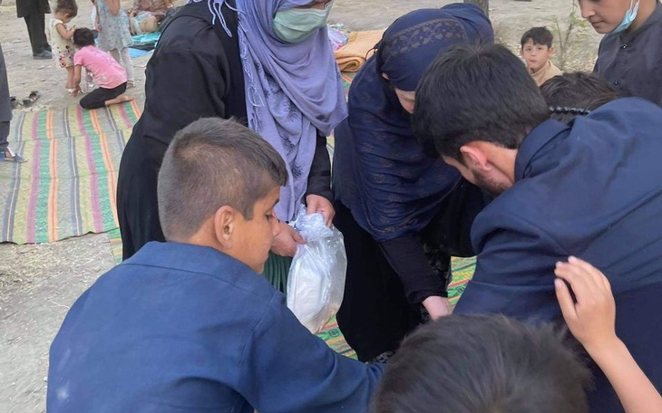 Grupa ludzi zbierająca się wokół, dzieląca się jedzeniem.