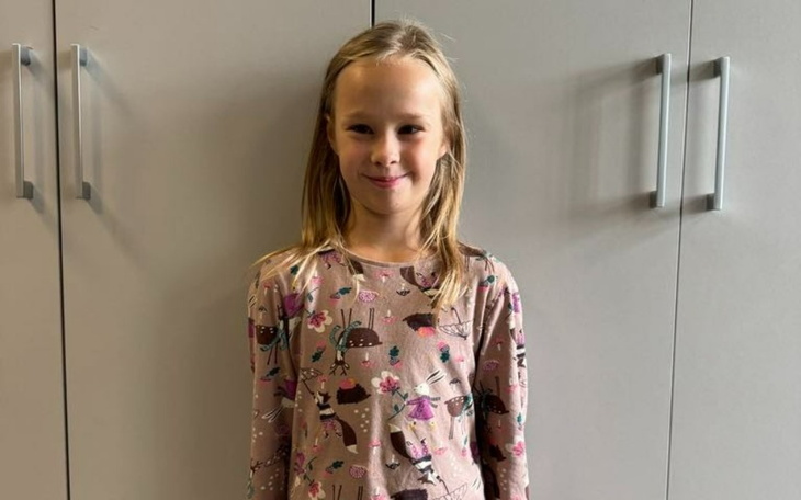 Uśmiechnięta dziewczynka w kolorowej bluzce.