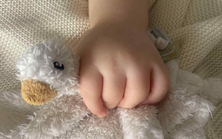 Dziecięca rączka trzymająca pluszowego zwierzaka.