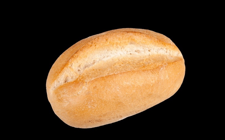 Chleb na czarnym tle, świeżo upieczony i chrupiący.