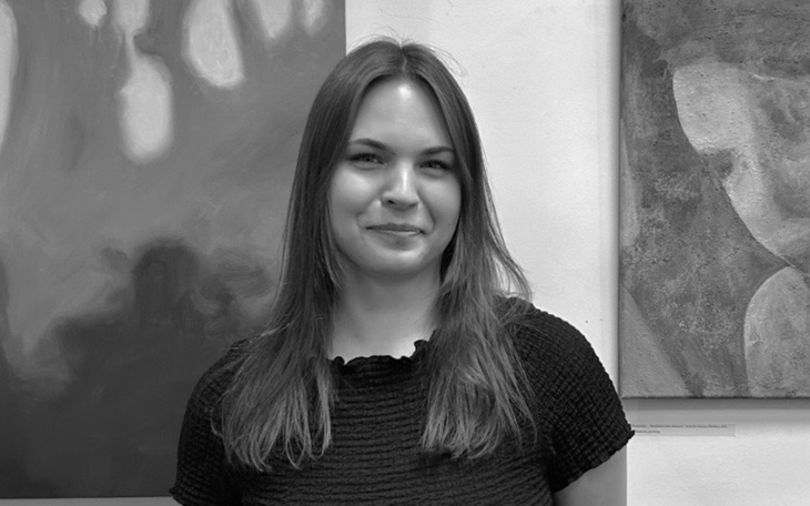 Portret uśmiechniętej kobiety w czarno-białej tonacji.