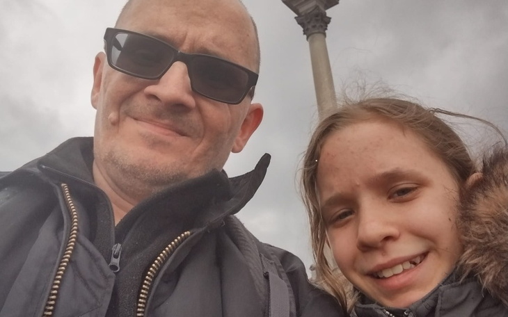 Rodzinne selfie w parku, uśmiechnięte twarze.