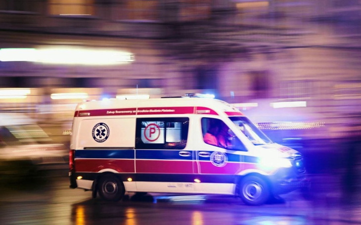 Karetka pogotowia w akcji, z włączonymi sygnałami świetlnymi.