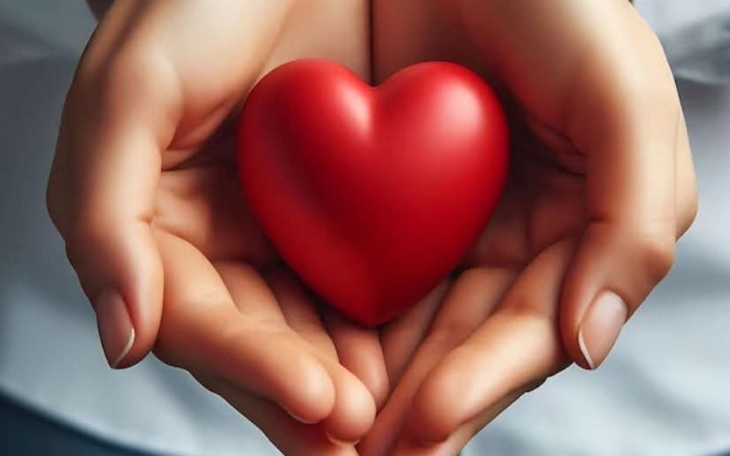 Dwie ręce trzymające czerwone serce, symbol miłości.