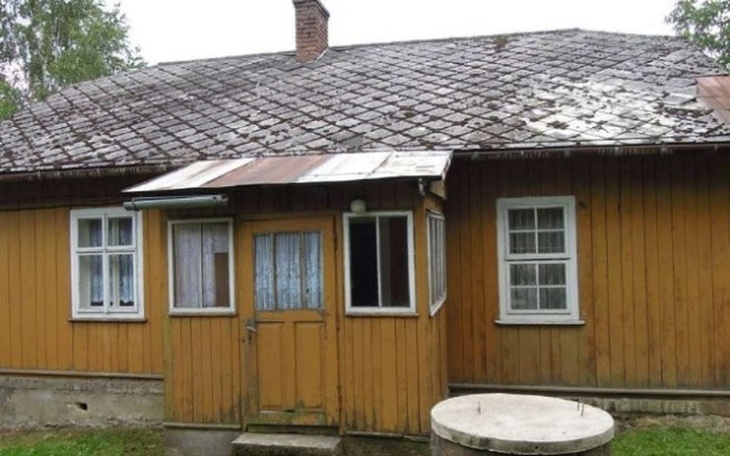 Stary drewniany dom z dachem pokrytym blachą.