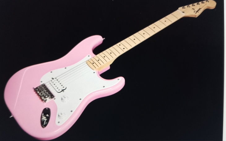 Różowa gitara elektryczna na czarnym tle.