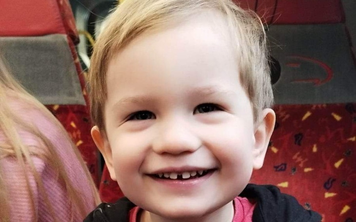 Mały chłopiec z szerokim uśmiechem w autobusie.