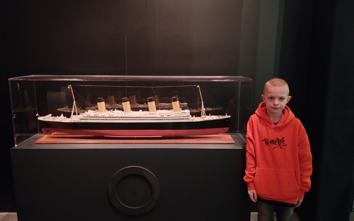 Chłopiec przy modelu statku Titanic w muzeum.