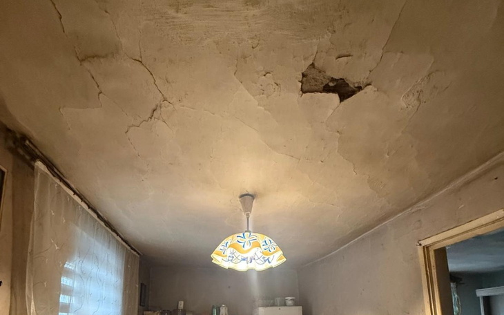 Zniszczony sufit w pomieszczeniu z lampą.