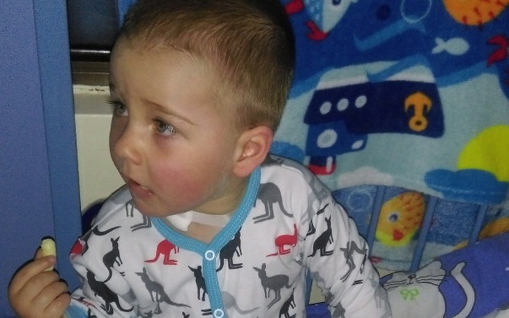 Chłopiec w piżamie, patrzący w bok.