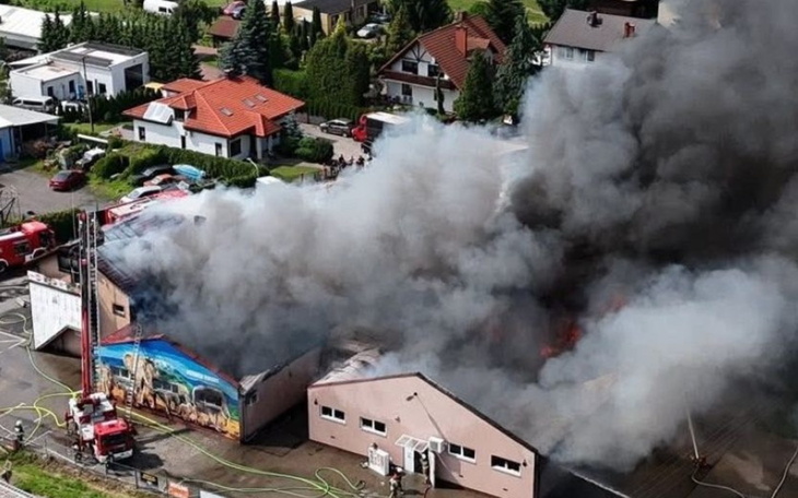 Pożar budynku, gęsty dym unoszący się nad dachami domów.