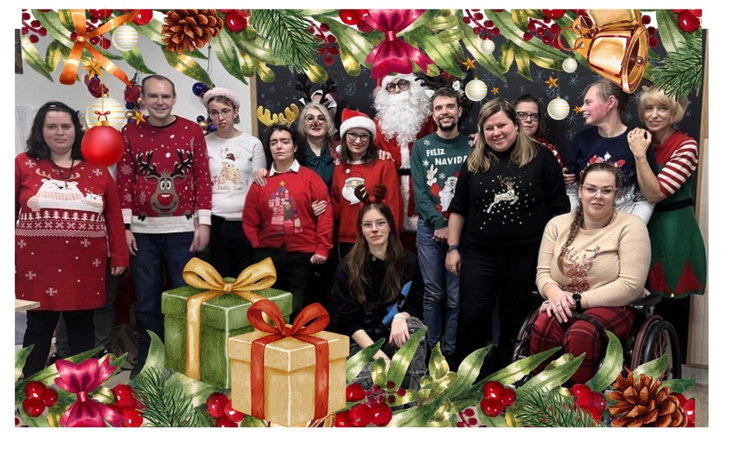 Grupa ludzi w świątecznych swetrach na tle dekoracji.