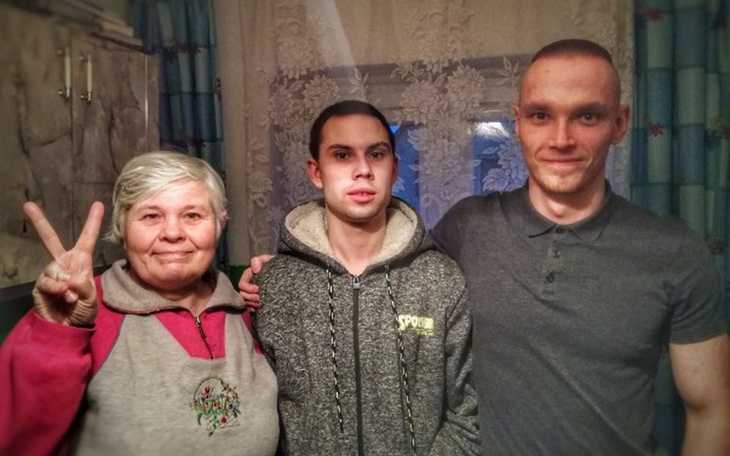 Rodzina pozująca razem w domowym otoczeniu, z uśmiechami na twarzach.