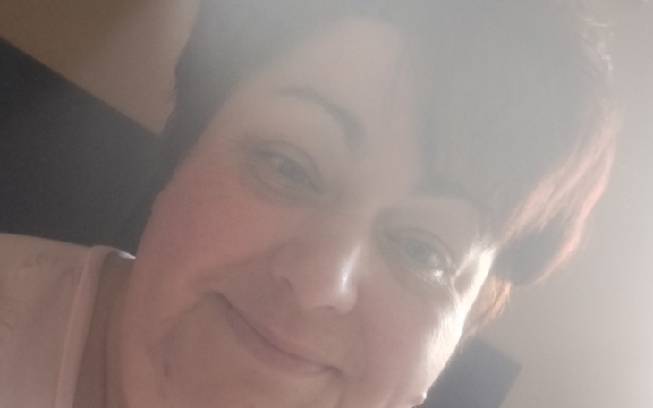 Kobieta z uśmiechem, patrząca w stronę kamery.