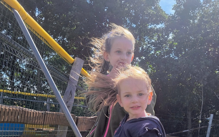 Dwie dziewczynki na placu zabaw, wietrzny dzień.