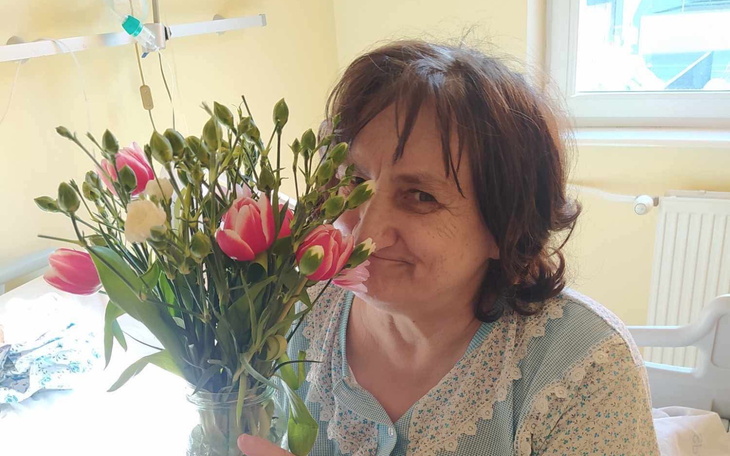 Kobieta trzymająca bukiet kwiatów, uśmiechająca się.