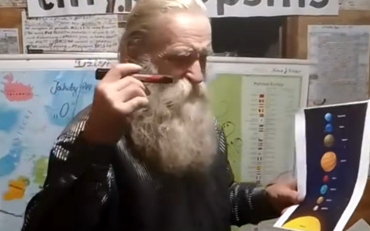 Mężczyzna z długą brodą, prezentujący materiały edukacyjne.