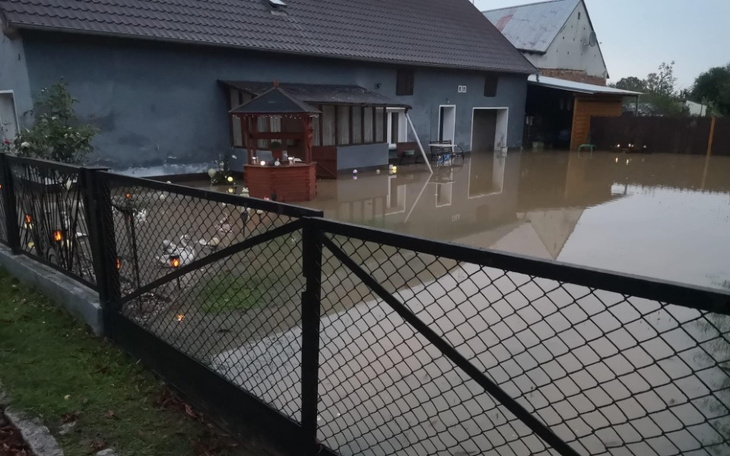 Zalany teren wokół domu, z widoczną wodą.