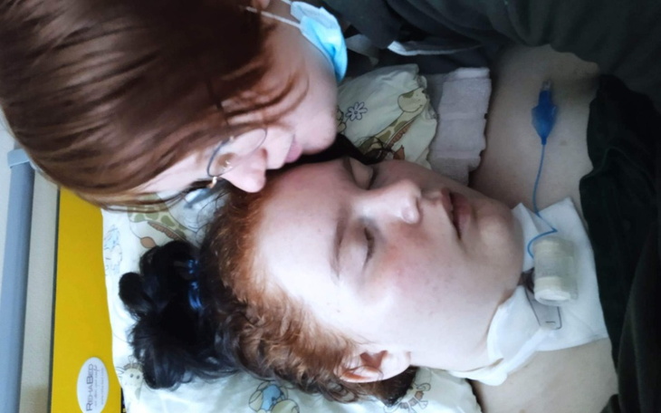 Dwie osoby w szpitalu, jedna z nich leży na łóżku.