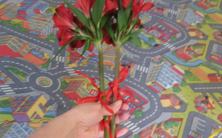 Ręka trzymająca bukiet kwiatów, wyrażająca uczucia i emocje.