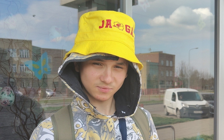 Młody chłopak w żółtej czapce, patrzący w obiektyw.