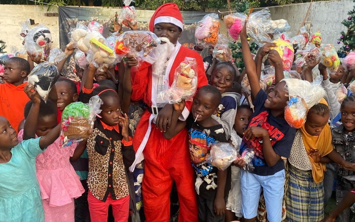 Grupa dzieci z prezentami w rękach, świętujących razem.
