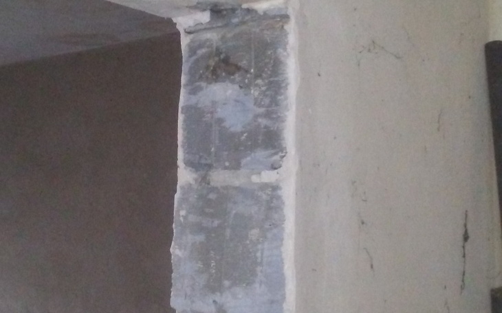 Fragment ściany z widocznymi uszkodzeniami i tynkiem.