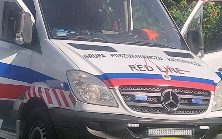 Ambulans z logo grupy poszukiwawczo-ratowniczej.