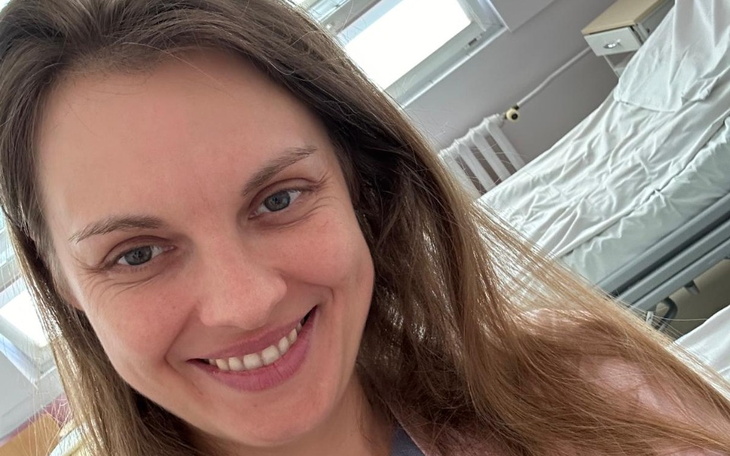 Uśmiechnięta kobieta w szpitalu, robiąca selfie.