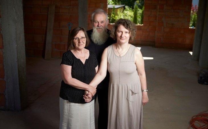 Trzy osoby stojące razem w nieukończonym budynku.