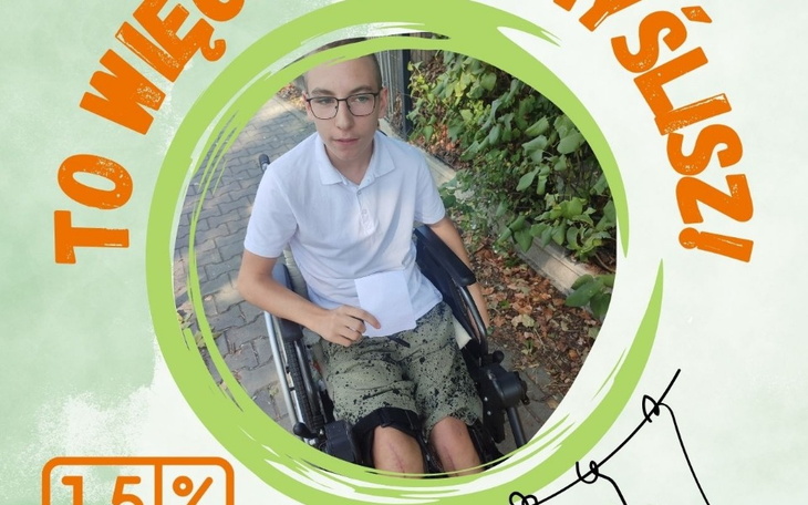 Chłopak na wózku inwalidzkim, trzyma kartkę w ręku.