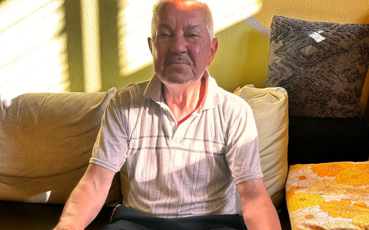 Starszy mężczyzna siedzący na kanapie w świetle słonecznym.