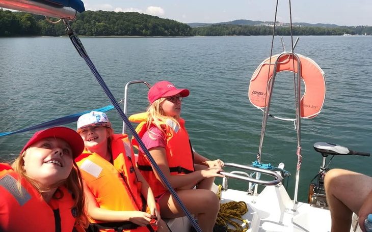 Dzieci na łódce, cieszą się z rejsu.